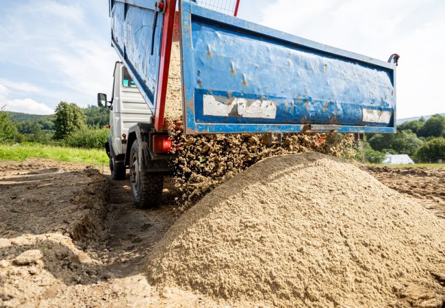 Unloading the truck with the soil and sand at construction site